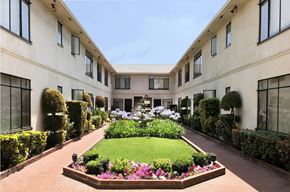 Los Angeles apartment for rent - A garden in front of a building with a lawn and flowers.