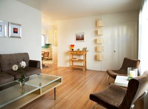 Los Angeles apartment for rent - A living room with a grey couch, a glass coffee table, and a brown chair.