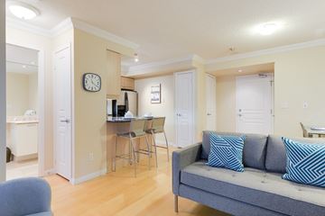 Toronto apartment for rent - A living room with a grey couch and a white desk with a computer.
