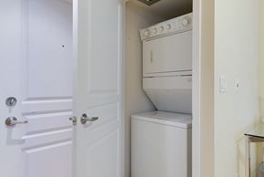 Toronto apartment for rent - A white door is open to a small kitchen with a white oven and dishwasher.