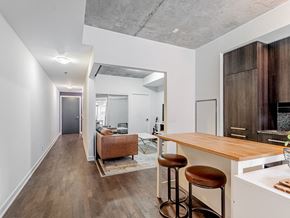 Toronto apartment for rent - A modern kitchen with a bar stool and a counter.