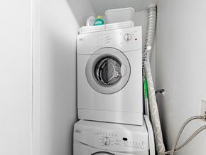 Toronto apartment for rent - A white washing machine is stacked on top of another in a small space.
