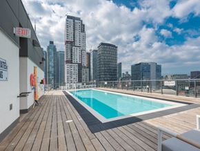 Toronto apartment for rent - A pool on a rooftop with a cityscape in the background.