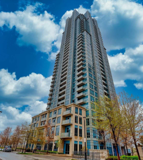 Toronto apartment for rent - A tall building with a blue sky and clouds in the background.