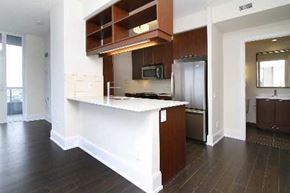Toronto apartment for rent - A kitchen with dark wood floors and white walls.