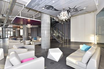 Toronto apartment for rent - A modern living room with white furniture and a chandelier.