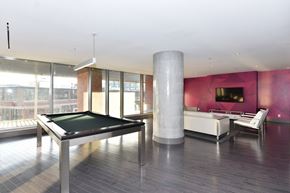 Toronto apartment for rent - A pool table is in the middle of a room with a couch and a television.