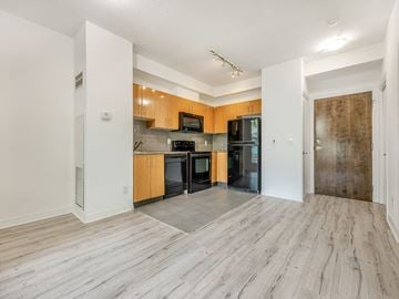 Toronto apartment for rent - A kitchen with wooden cabinets and black appliances.