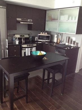 Toronto apartment for rent - A kitchen with a black table and stools.
