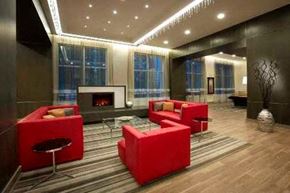 North York apartment for rent - A modern living room with a fireplace and red furniture.