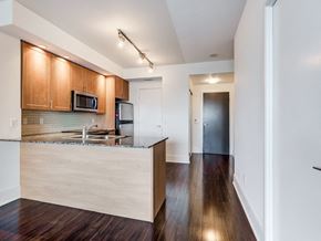 North York apartment for rent - A kitchen with wooden cabinets and a granite countertop.