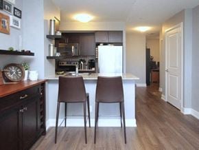 Etobicoke apartment for rent - A kitchen with brown chairs and a white fridge.