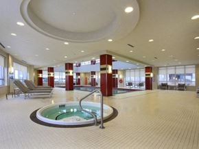 Etobicoke apartment for rent - A large indoor swimming pool with a hot tub in the middle.