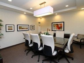 Etobicoke apartment for rent - A conference room with a glass table and white chairs.