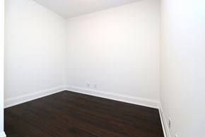 Toronto apartment for rent - A room with wooden flooring and white walls.