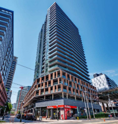 Toronto apartment for rent - A tall building with a lot of windows in the middle of a city.