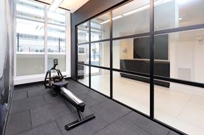 Toronto apartment for rent - A gym room with a bench and a treadmill.