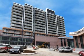 Mississauga apartment for rent - A large building with a parking lot in front of it.