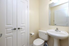 Mississauga apartment for rent - A white toilet sits next to a white sink in a bathroom.