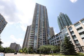 Mississauga apartment for rent - A tall building stands in the middle of a city park.