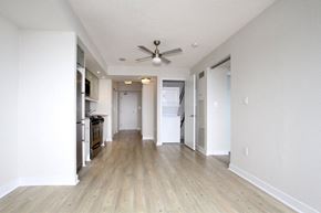 Toronto apartment for rent - A long hallway with a ceiling fan and a kitchen area on the left.