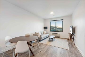 Park City apartment for rent - A living room with a round table and chairs, a couch, and a television.
