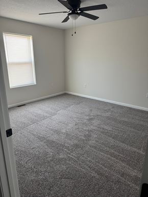 Mccomb apartment for rent - A room with a ceiling fan and carpeted floor.