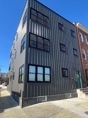 Baltimore apartment for rent - A tall building with a striped facade and a green door.
