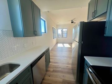 Baltimore apartment for rent - A kitchen with dark green cabinets and a black refrigerator.