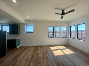 Baltimore apartment for rent - A room with wooden floors and a ceiling fan.