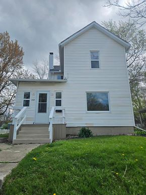 Lima house for rent - A white house with a grey door and a small porch.