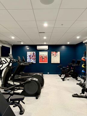 Bedford apartment for rent - A gym with exercise equipment and artwork on the wall.
