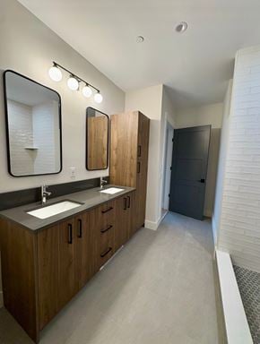 Bedford apartment for rent - A bathroom with a sink, mirror, and lighting fixtures.