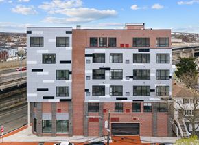 Bayonne apartment for rent - A modern building with a combination of white and red brick and black accents.