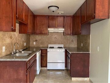 North Hills apartment for rent - A kitchen with brown cabinets and a white stove.