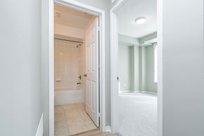 Mississauga apartment for rent - A white bathroom with a tub and a toilet.