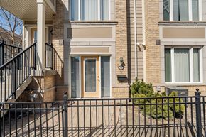 Mississauga apartment for rent - A brick building with a black fence in front.
