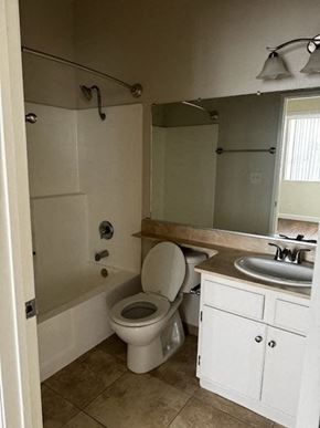 Los Angeles apartment for rent - A white toilet in a bathroom with a sink and mirror.