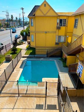 North Hills apartment for rent - A yellow building with a pool in the backyard.