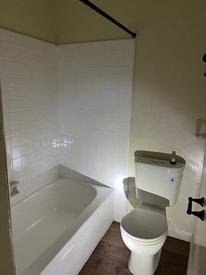 Canoga Park apartment for rent - A white toilet in a bathroom with a white tiled wall.
