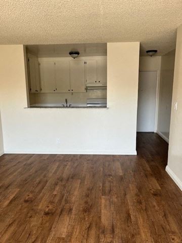 Canoga Park apartment for rent - A kitchen with white cabinets and a wooden floor.