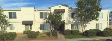 Chula Vista apartment for rent - A white building with a brown roof and a tree in front.