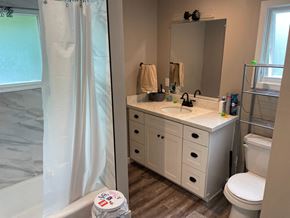 San Luis Obispo house for rent - A white bathroom with a toilet, sink, and mirror.