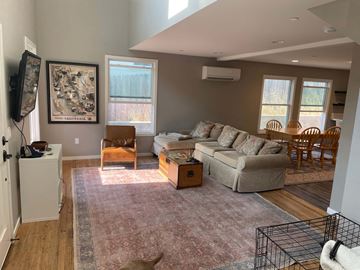 San Luis Obispo house for rent - A dog is sitting on a rug in a living room with a couch, chairs, and a television.