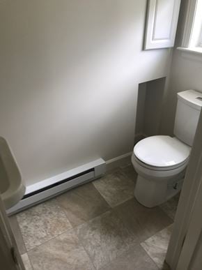 West Lawn house for rent - A white toilet in a bathroom with tiled flooring and a window.