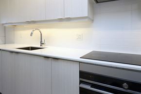 Mississauga apartment for rent - A modern kitchen with white cabinets and a black oven.