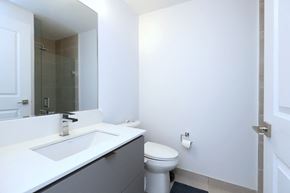 Mississauga apartment for rent - A white toilet sits next to a sink in a bathroom.