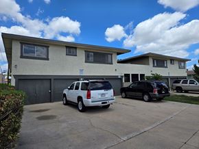 Downey apartment for rent - A white SUV is parked in front of a two-story house.