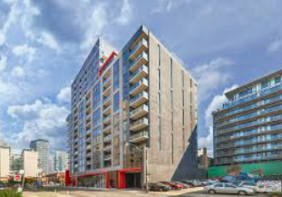 Toronto apartment for rent - A tall building with a red and white striped awning in front of it.