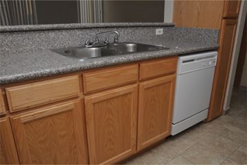 Los Angeles apartment for rent - A kitchen with wooden cabinets and a white dishwasher.